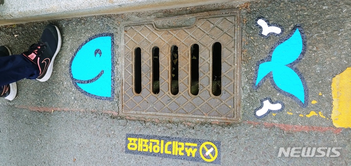 [창원=뉴시스] 경남도, 도청 인근 도로 우수관에 돌고래 모양 스티커 부착.(사진=경남도 제공)