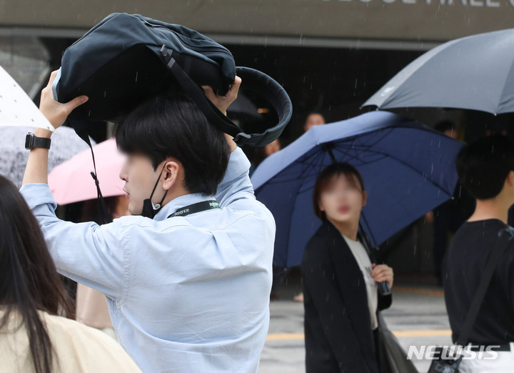 [서울=뉴시스] 황준선 기자 = 지난 8일 오후 서울 중구 서울시청 인근에서 한 시민이 가방을 이용해 비를 피하고 있다. 2023.06.08. hwang@newsis.com