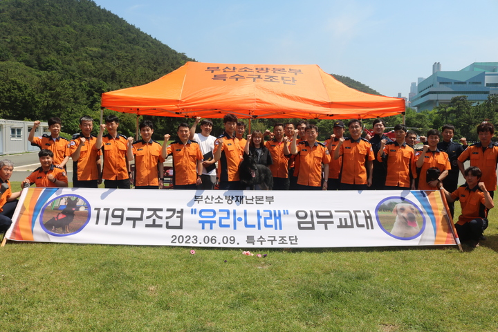 [부산=뉴시스] 9일 오전 부산소방재난본부 특수구조단에서 (사진 가운데 왼쪽부터) 구조견 '유리'를 비롯한 임무교대식 참석자들이 기념사진을 촬영하고 있다. (사진=부산소방재난본부 제공) *재판매 및 DB 금지