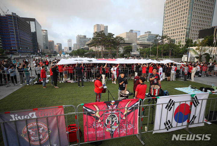 [서울=뉴시스] 김진아 기자 = 2023 FIFA U-20 월드컵 준결승 대한한국과 이탈리아의 경기가 열린 9일 오전 서울 종로구 광화문광장에서 붉은악마와 시민들이 애국가가 나오자 태극기를 펼치고 있다. 2023.06.09. bluesoda@newsis.com