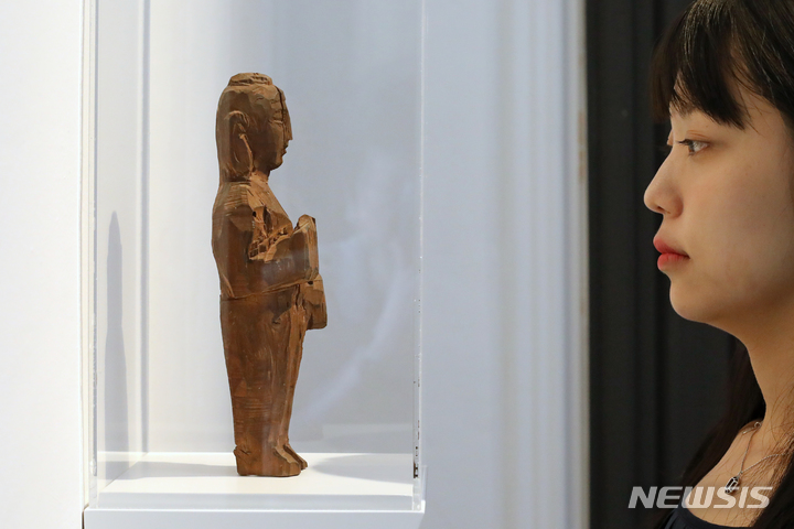 [서울=뉴시스] 박진희 기자 = 권진규(1922-1973) 작고 50주기를 맞아 서울 관악구 서울시립 남서울미술관에서 열린 상설전 '권진규의 영원한 방' 전시작&nbsp; '불상'(1970년대). '불상'은 시무외인施無畏印(손을 가슴 위로 들어 올리고, 손바닥을 밖으로 향하게 한 모습으로 '두려워하지 말라'라는 뜻이다)과 여원인與願印(손바닥을 밖으로 하여 내린 손 모양으로, 중생이 원하는 바를 이루게 한다는 뜻이다)의 수인을 한 불상을 제작하다가 미완으로 남겨진 목조각이다. 얼굴이 완전히 마무리된 상태가 아니기 때문에 신체 비율을 정확히 판단하기는 어렵지만 5등신에 가까울 정도로 머리가 크다. 이 작품은 일본 유학 시기 제작한 것으로 알려진 '보살입상'(1955)처럼 머리의 중앙부를 봉긋하게 올리고 나발은 묘사하지 않았다. 권진규는 1970년대 제작한 불상에서도 도상을 엄격하게 지키지 않았는데, 그것은 불상의 제작 과정이 그에게 제작 과정을 통해 자신을 성찰하는 통로이자 독자적인 창작물이었기 때문이다. 이 작품의 경우 얼굴 윤곽은 다 잡혀 있으나 보살을 상징하는 장신구가 보이지 않고, 시무외인과 여원인을 한 것으로 보아 아미타불과 같은 불입상을 조각하려고 했던 것으로 보인다. 2023.06.10. pak7130@newsis.com