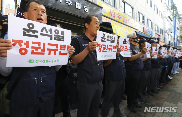 [서울=뉴시스] 최진석 기자 = 민주노총 전국건설노조 조합원들이 9일 경찰이 서울 도심 1박2일 집회와 관련해 압수수색에 나선 서울 영등포 대림로 민주노총 건설노조 사무실 앞에서 정권 규탄 피켓을 들고 구호릉 외치고 있다. 2023.06.09. myjs@newsis.com