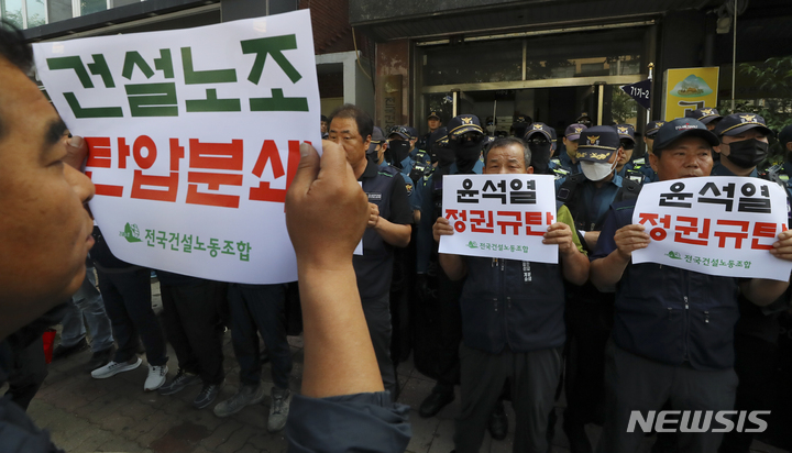[서울=뉴시스] 최진석 기자 = 민주노총 전국건설노조 조합원들이 9일 경찰이 서울 도심 1박2일 집회와 관련해 압수수색에 나선 서울 영등포 대림로 민주노총 건설노조 사무실 앞에서 정권 규탄 피켓을 들고 구호릉 외치고 있다. 2023.06.09. myjs@newsis.com