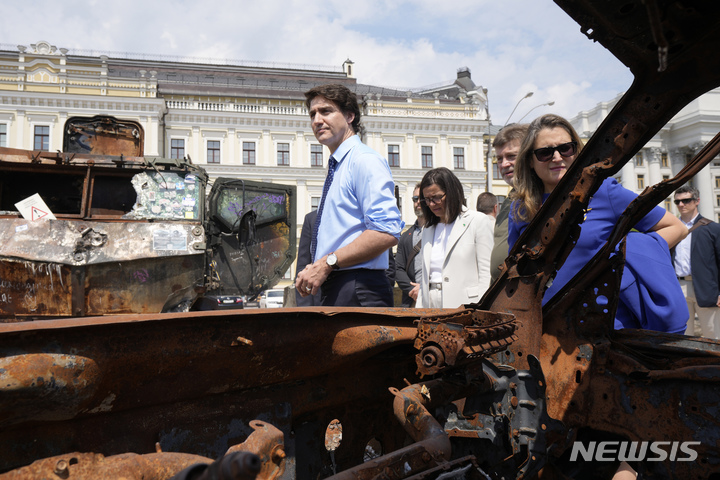 [키이우=AP/뉴시스] 10일(현지시간) 우크라이나 수도 키이우를 깜짝 방문한 쥐스탱 트뤼도 캐나다 총리가 크리스티아 프리랜드 부총리 겸 재무장관과 함께 전소된 러시아 탱크 옆을 지나고 있다. 2023.06.10.