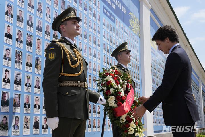 [키이우=AP/뉴시스] 쥐스탱 트뤼도 캐나다 총리가 10일(현지시간) 우크라이나 수도 키이우를 깜짝 방문해 추모의 벽에 헌화하고 있다. 2023.06.10.