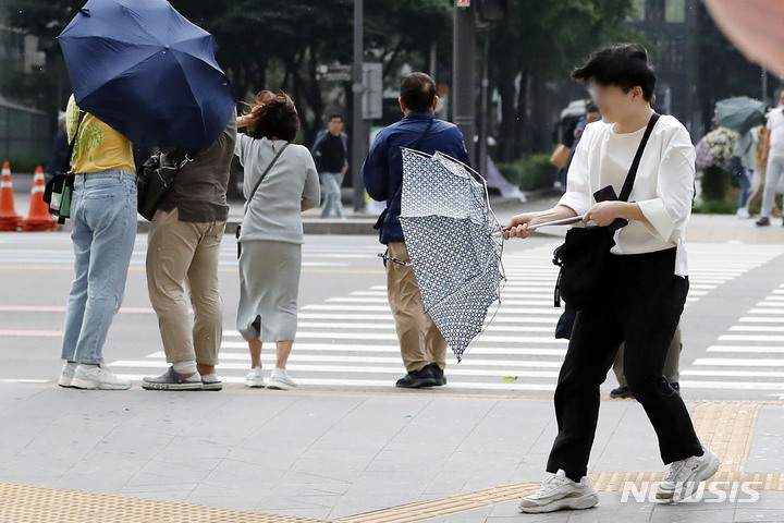 [서울=뉴시스] 최동준 기자 = 20일 화요일은 전국이 대체로 흐린 가운데 일부 지역에서 오전부터 천둥·번개를 동반한 비가 내릴 것으로 보인다. 사진은 소나기가 내린 지난 10일 서울 광화문 네거리에서 한 시민이 강풍에 우산을 붙잡는 모습. 2023.06.10. photocdj@newsis.com *재판매 및 DB 금지