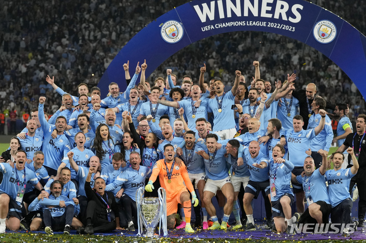 [이스탄불=AP/뉴시스] 맨체스터 시티 선수들과 스태프들이 10일(현지시각) 튀르키예 이스탄불의 아타튀르크 올림픽 스타디움에서 열린 2022~23 유럽축구연맹(UEFA) 챔피언스리그(UCL) 정상에 올라 트로피를 놓고 기념 촬영하고 있다. 펩 과르디올라 감독이 이끄는 맨시티는 인테르 밀란(이탈리아)을 1-0으로 꺾고 EPL, FA컵, UCL을 모두 우승하는 '트레블'(3관왕)을 달성했다. 2023.06.11. 
