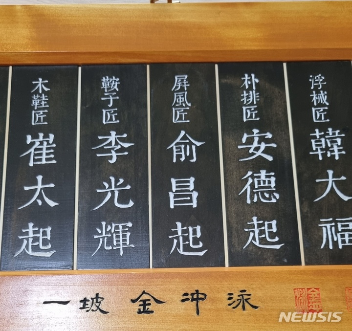  서각으로 이름을 새기고 있는 화성 축성 작업자들. [수원=뉴시스]=이준구 기자