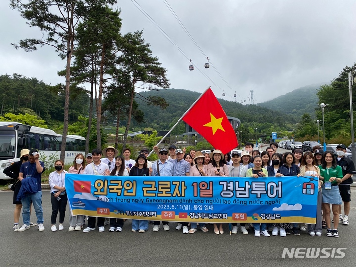 [통영=뉴시스] 홍정명 기자=11일 경남이주민센터 주최 '외국 인근로자 1일 경남 투어' 행사에 참여한 경남베트남교민회 소속 외국인 근로자들이 통영 케이블카 탑승 체험에 앞서 기념촬영하고 있다.(사진=경남이주민센터 제공)2023.06.11. photo@newsis.com