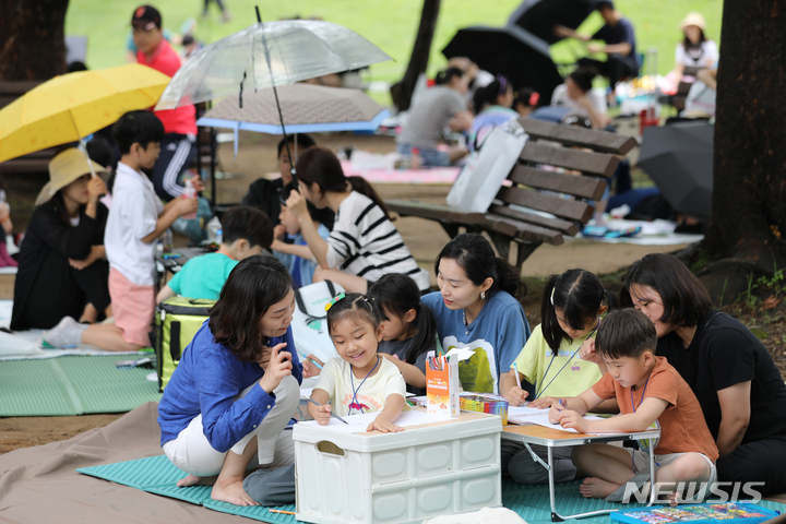 [서울=뉴시스] 김금보 기자 = 11일 서울 송파구 올림픽공원피크닉장에서 열린 '제41회 롯데 어린이 환경 미술대회'에 참가한 어린이와 가족들이 그림을 그리고 있다. 2023.06.11. kgb@newsis.com