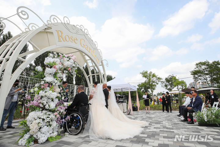 [서울=뉴시스] 권창회 기자 = 서울 강동구 광나루 한강공원 장미원에서 한 부부의 야외결혼식이 진행되고 있다. 2023.06.11. kch0523@newsis.com