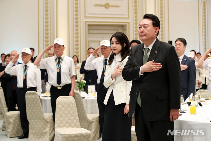 [서울=뉴시스] 전신 기자 = 윤석열 대통령과 부인 김건희 여사가 14일 청와대 영빈관에서 열린 국가유공자 및 보훈가족 초청 오찬에서 국기에 대한 경례를 하고 있다. 2023.06.14. photo1006@newsis.com