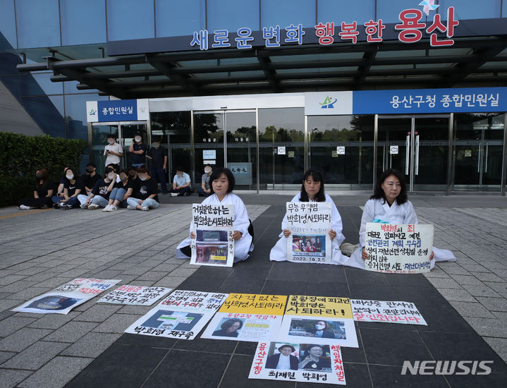 [서울=뉴시스] 조수정 기자 = 16일 오전 서울 용산구청에서 이태원 참사 유족들이 구청장 사퇴를 촉구하는 피켓 시위를 하고 있다. 유족의 왼쪽 뒤에 있는 이들은 14명의 구청 직원들. 이날 오전 유족들은 구청 외곽을 돌아 출입문으로 진입을 시도했으나 10여명의 구청 직원들이 둘러싸고 막아서 진입도, 구청장을 만나지도 못했다. 자신이 구청 직원이 맞다고 답한 A씨는 기자의 "구청의 지시로 문을 막는거냐"는 질문에 "지시받은건 아니"라고 답했다. "그러면 자발적인 것이냐"는 질문에는 답변하지 않았다. 2023.06.16. chocrystal@newsis.com