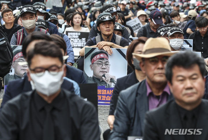 [서울=뉴시스] 김근수 기자 = 건설노조 故 양회동씨의 장례절차가 시작된 17일 서울 중구 세종대로 인근에서 열린  故 양회동 열사 범국민 추모대회에서 조합원들이 추모영상을 시청하고 있다. 2023.06.17. ks@newsis.com