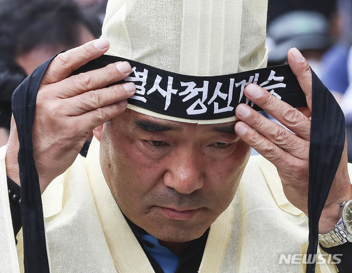 [서울=뉴시스] 김근수 기자 = 건설노조 故 양회동씨의 장례절차가 시작된 17일 서울 중구 세종대로 인근에서 열린  故 양회동 열사 범국민 추모대회에서 장옥기 건설노조 위원장이 머리띠를 묶고 있다. 2023.06.17. ks@newsis.com