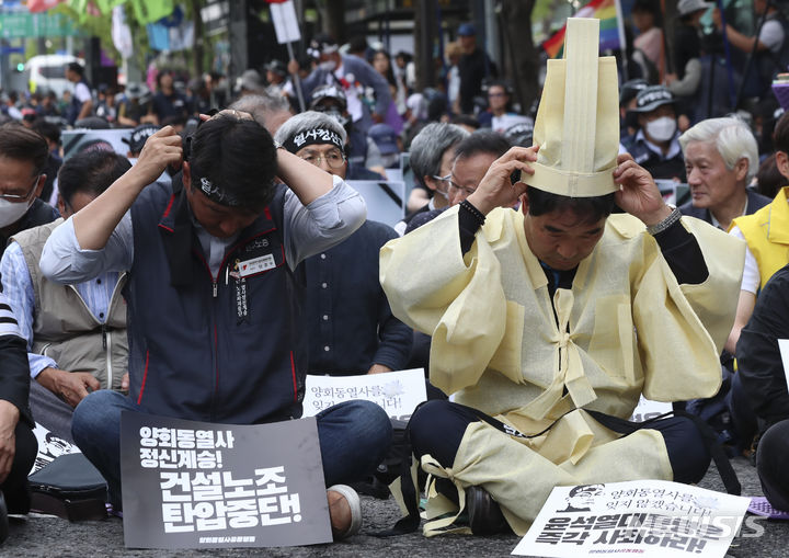 [서울=뉴시스] 김근수 기자 = 건설노조 故 양회동씨의 장례절차가 시작된 17일 서울 중구 세종대로 인근에서 열린  故 양회동 열사 범국민 추모대회에서 양경수 민주노총 위원장과 장옥기 건설노조 위원장이 머리띠를 묶고 있다. 2023.06.17. ks@newsis.com