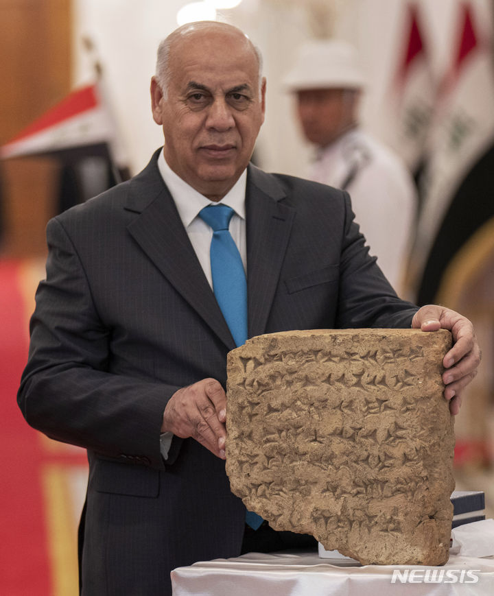 [바그다드(이라크)=AP/뉴시스] 이라크정부가 이탈리아로부터 반환받은 고대 설형문자가 새겨진 석판을 6월 18일 이라크의 아흐메드 파카크 알-바드라니 문화부장관이 바그다드 평화궁전의 전시회에서 들어보이고 있다.&nbsp; 