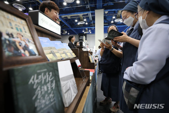 [서울=뉴시스] 김명년 기자 = 18일 오전 서울 강남구 코엑스에서 열린 2023 서울국제도서전에서 관람객들이 책을 살펴보고 있다. 2023.06.18 kmn@newsis.com