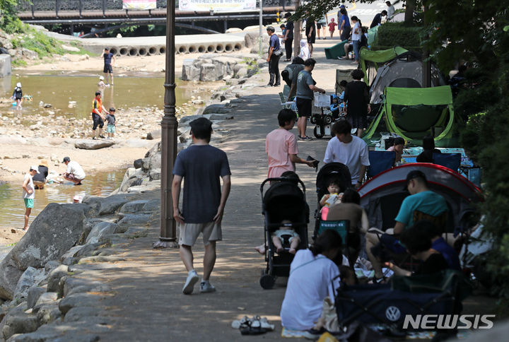 [과천=뉴시스] 김명년 기자 = 서울에 올해 첫 폭염특보가 내려진 18일 오후 경기 과천시 과천향교 인근 계곡을 찾은 시민들이 텐트에서 더위를 식히고 있다. 2023.06.18 kmn@newsis.com