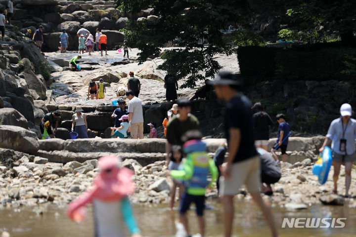 [과천=뉴시스] 김명년 기자 = 서울에 올해 첫 폭염특보가 내려진 18일 오후 경기 과천시 과천향교 인근 계곡을 찾은 시민들이 물놀이를 하며 더위를 식히고 있다. 2023.06.18 kmn@newsis.com