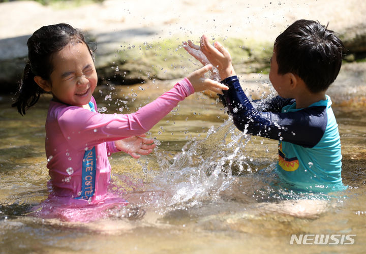 [과천=뉴시스] 김명년 기자 = 서울에 올해 첫 폭염특보가 내려진 18일 오후 경기 과천시 과천향교 인근 계곡에서 아이들이 물놀이를 하며 더위를 식히고 있다. 2023.06.18 kmn@newsis.com