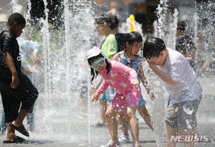 [서울=뉴시스] 김진아 기자 = 서울을 비롯한 중부내륙 곳곳에 폭염주의보가 내려진 18일 서울 종로구 광화문광장 분수에서 어린이들이 물놀이를 즐기고 있다. 2023.06.18. bluesoda@newsis.com