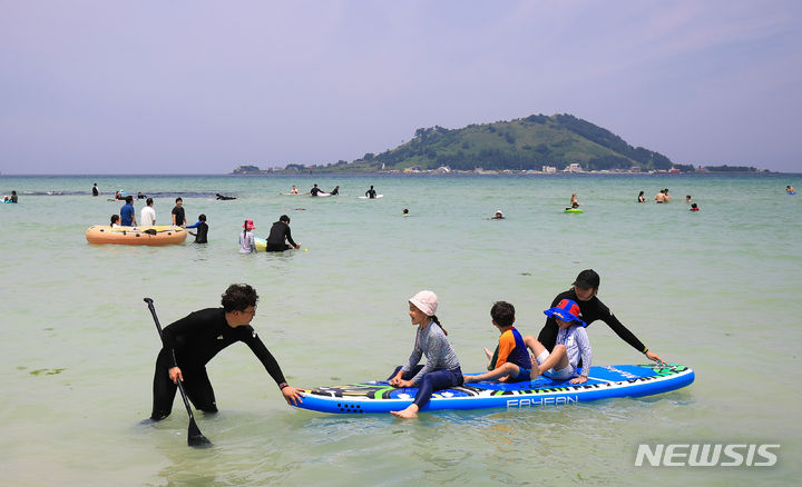 [제주=뉴시스] 우장호 기자 = 전국적으로 더운 날씨를 보인 19일 오후 제주시 한림읍 협재해수욕장을 찾은 나들이객들이 시원한 바닷물에 몸을 담그며 더위를 식히고 있다. 2023.06.19. woo1223@newsis.com