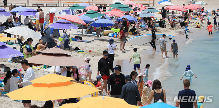 [제주=뉴시스] 우장호 기자 = 전국적으로 더운 날씨를 보인 19일 오후 제주시 한림읍 협재해수욕장을 찾은 나들이객들이 시원한 바닷물에 발을 담그며 더위를 식히고 있다. 2023.06.19. woo1223@newsis.com