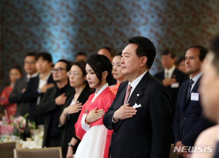 [파리=뉴시스] 홍효식 기자 = 윤석열 대통령과 부인 김건희 여사가 19일(현지시간) 파리 한 호텔에서 열린 프랑스 동포 초청 만찬 간담회에서 국기에 대한 경례를 하고 있다. 2023.06.20. yesphoto@newsis.com