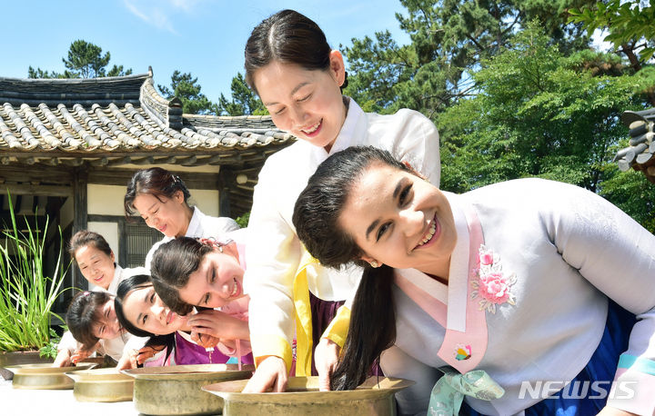 [경산=뉴시스] 이무열 기자 = 단오를 이틀 앞둔 20일 오전 경북 경산시 영남대학교 민속촌에서 외국인 유학생들이 한복을 곱게 차려입고 창포물에 머리를 감고 있다. 2023.06.20. lmy@newsis.com