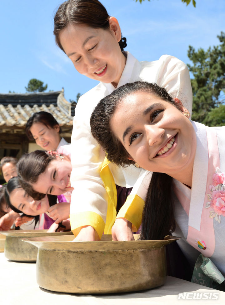 [경산=뉴시스] 이무열 기자 = 단오를 이틀 앞둔 20일 오전 경북 경산시 영남대학교 민속촌에서 외국인 유학생들이 한복을 곱게 차려입고 창포물에 머리를 감고 있다. 2023.06.20. lmy@newsis.com