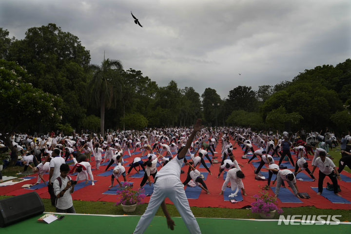 [뉴델리=AP/뉴시스] '세계 요가의 날'인 21일(현지시각) 인도 뉴델리에서 시민들이 요가를 하고 있다. 힌두교 현자들이 처음 행한 고대 요가는 발리우드 이후 인도에서 가장 성공적인 문화 수출품 중 하나가 됐으며 인도 외교의 한 부분으로 자리 잡기도 했다. 2023.06.21.