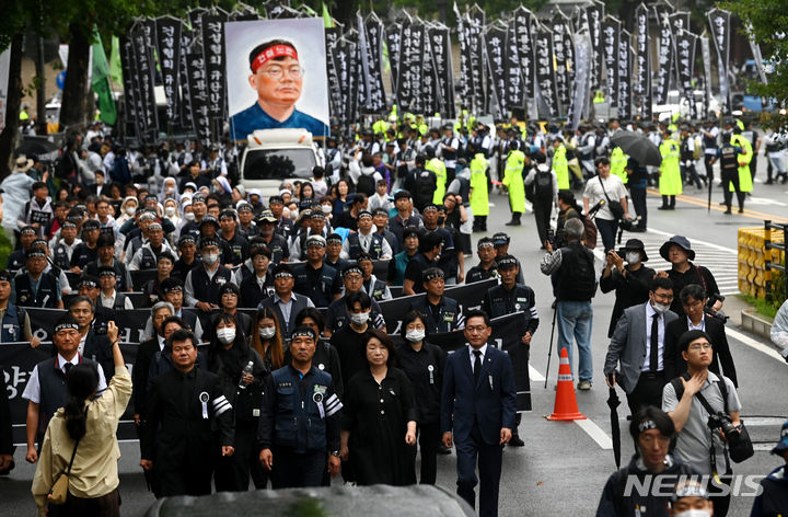 [서울=뉴시스] 김금보 기자 = 건설노조 故 양회동씨의 노동시민사회장 마지막 날인 21일 오전 서울 종로구 서울대학교병원 장례식장에서 출발한 운구행렬이 노제를 위해 경찰청으로 향하고 있다. (공동취재사진) 2023.06.21. photo@newsis.com