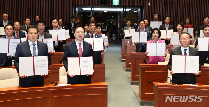 [서울=뉴시스] 이영환 기자 = 김기현 국민의힘 대표와 윤재옥 원내대표 등 의원들이 21일 오후 서울 여의도 국회에서 열린 의원총회를 마친 후 국회의원 불체포특권 포기 서약식을 하고 있다. 2023.06.21. 20hwan@newsis.com