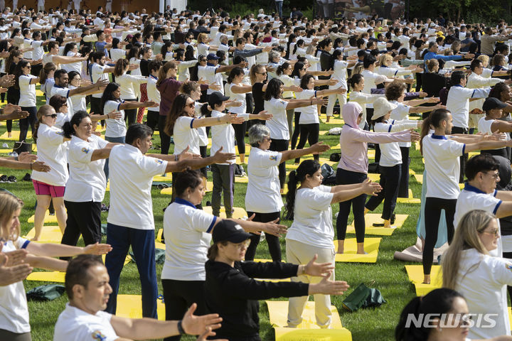 [뉴욕=AP/뉴시스] 21일(현지시간) 미국 뉴욕 유엔본부에서 열린 세계 요가의 날 행사에 참여한 시민들이 요가를 하고 있다. 2023.06.22.