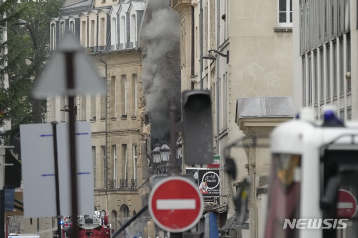 [파리=AP/뉴시스] 21일(현지시각) 프랑스 파리에서 소방관들이 연기가 피어오르는 건물의 화재를 진압하고 있다. 2023.06.22.