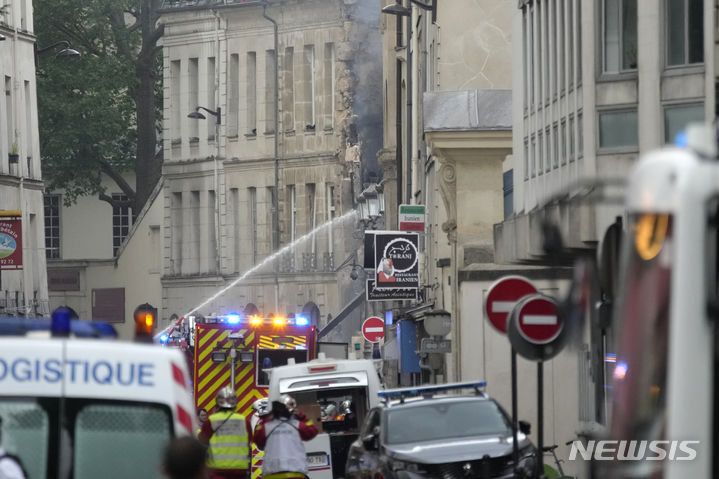 [파리=AP/뉴시스] 21일(현지시각) 프랑스 파리에서 소방관들이 연기가 피어오르는 건물의 화재를 진압하고 있다. 2023.06.22.