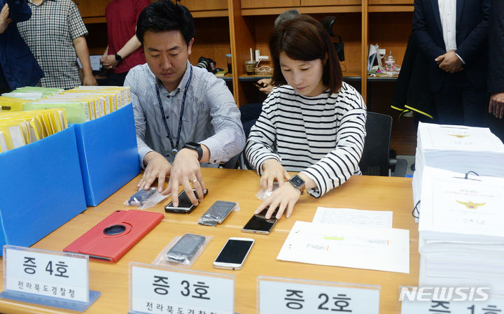 [전주=뉴시스] 김얼 기자 = 백선기 경사 살인사건과 관련한 브리핑이 열린 22일 전북 전주시 전북경찰청 기자실에서 경찰관들이 증거자료를 정리하고 있다. 2023.06.22. pmkeul@nwsis.com