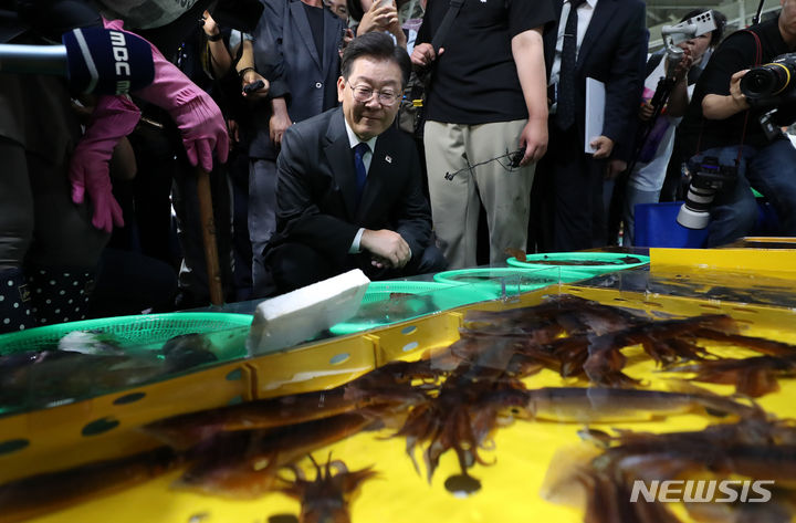 [강릉=뉴시스] 이영환 기자 = 이재명 더불어민주당 대표가 22일 오후 강원 강릉시 주문진 좌판풍물시장을 찾아 수산물을 살펴보고 있다. 2023.06.22.2023.06.22. 20hwan@newsis.com