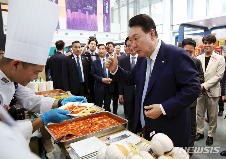 [하노이=뉴시스] 전신 기자 = 베트남을 국빈 방문한 윤석열 대통령이 22일(현지시간) 하노이 국가컨벤션센터에서 열린 한-베트남 파트너십 박람회에서 K-Food 행사장을 찾아 떡볶이를 시식한 뒤 엄지를 치켜 세우고 있다. 2023.06.22. photo1006@newsis.com