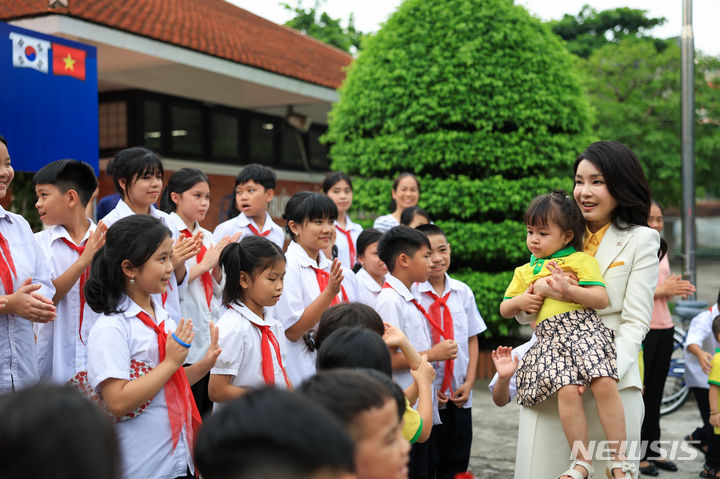 [하노이=뉴시스] 전신 기자 = 윤석열 대통령 부인 김건희 여사가 22일(현지시간) 하노이 SOS 어린이마을 학교에서 열린 '바이크 런(Bike Run)' 자전거 기부 행사를 마친 뒤 아이들과 인사하고 있다. (공동취재) 2023.06.22. photo1006@newsis.com