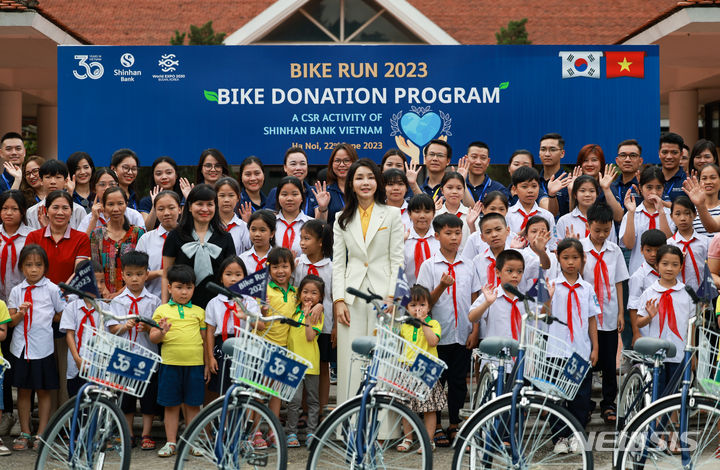 [하노이=뉴시스] 전신 기자 = 윤석열 대통령 부인 김건희 여사가 22일(현지시간) 하노이 SOS 어린이마을 학교에서 열린 '바이크 런(Bike Run)' 자전거 기부 행사에 참석해 기념촬영하고 있다. (공동취재) 2023.06.22. photo1006@newsis.com