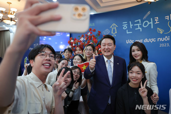 [하노이=뉴시스] 홍효식 기자 = 윤석열 대통령과 부인 김건희 여사가 22일(현지시간) 하노이 국가대학에서 열린 베트남 한국어 학습자와의 대화에서 참석자들과 기념촬영하고 있다. (공동취재) 2023.06.22. yesphoto@newsis.com