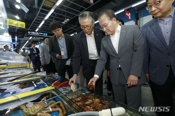 [서울=뉴시스] 최동준 기자 = 윤재옥 국민의힘 원내대표가 23일 서울 가락동 수산시장을 방문해 수산물 설명을 듣고 있다. 2023.06.23. photocdj@newsis.com