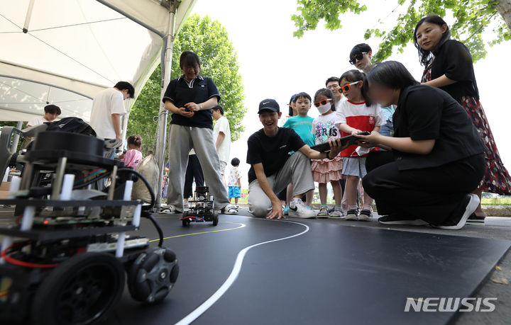 [서울=뉴시스] 황준선 기자 = 25일 오후 서울 용산구 용산어린이정원에서 열린 '로봇 그리고 인간: 로봇과 놀자' 행사를 찾은 어린이들이 자율주행 로봇 체험을 하고 있다. 2023.06.25. hwang@newsis.com