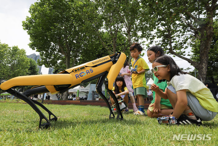 [서울=뉴시스] 황준선 기자 = 25일 오후 서울 용산구 용산어린이정원에서 열린 '로봇 그리고 인간: 로봇과 놀자' 행사를 찾은 어린이들이 사족보행 로봇 을 살펴보고 있다. 2023.06.25. hwang@newsis.com