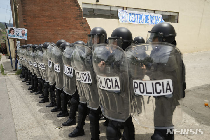 [과테말라시티= AP/뉴시스] 과테말라 대선이 치러진 25일 수도권의 산호세 엘골포 투표소에서 개소가 지연되는 데 항의하는 유권자들을 진압 경찰이 막고 있다.&nbsp; 