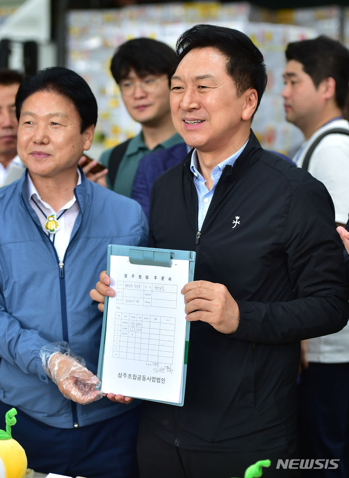 [성주=뉴시스] 이무열 기자 = 김기현 국민의힘 대표가 26일 오후 경북 성주군 성주농산물공판장을 찾아 성주 참외 400박스를 구매하고 있다. 2023.06.26. lmy@newsis.com