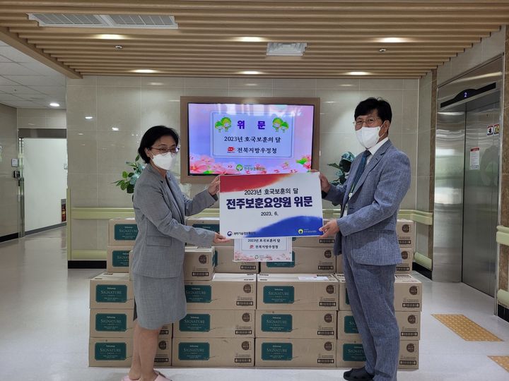 [전주=뉴시스] 김꽃마음 전북지방우정청장(왼쪽)이 27일 전주보훈병원 찾아 국가유공자 위문하고 물품을 전달하고 있다. 2023.06.27 (사진= 전북지방우정청 제공) *재판매 및 DB 금지