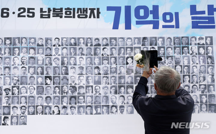 [파주=뉴시스] 조성우 기자 = 28일 오전 경기도 파주시 국립6·25전쟁납북자기념관에서 열린 6·25전쟁 납북희생자 기억의 날 행사에 참석한 한 유가족이 행사장에 걸린 사진을 휴대전화로 찍고 있다. 2023.06.28. xconfind@newsis.com